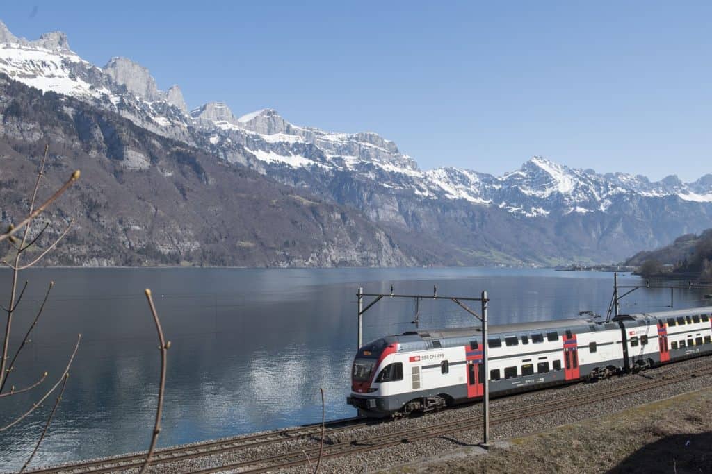 Swiss train by lake and mountains