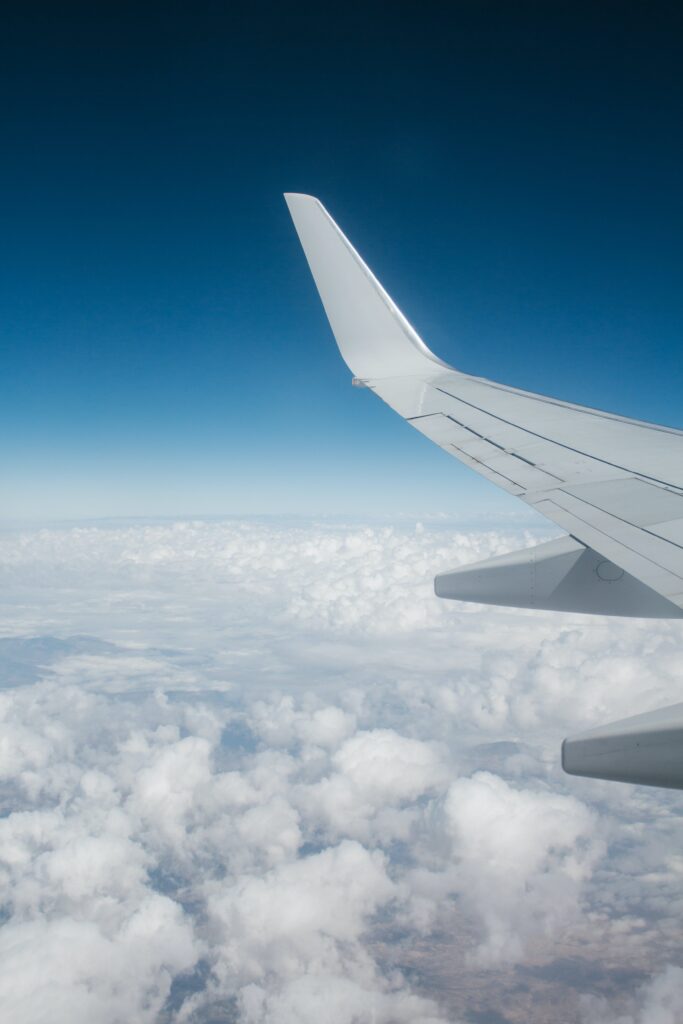 top reasons to move abroad airplane wing