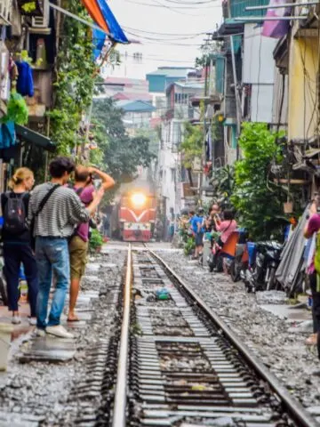 Popular place and One of the main attraction of Hanoi at Vietnam, Train passing through a narrow street in the Hanoi Old Houses, Transportation of Hanoi, Black soot from the chimney, Blur image.