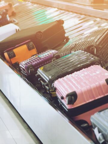 Suitcase or luggage with Circulating conveyor belt in the baggage claim in the international airport.