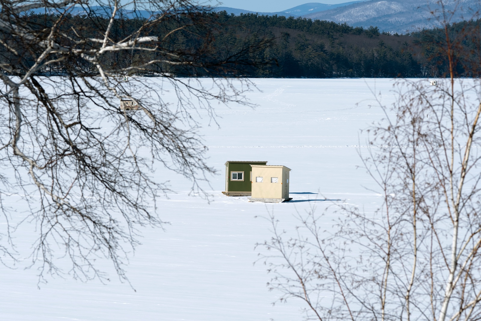 Portable Ice Fishing Bob-Houses on snow covered Lake Winnipesaukee near the White Mountains of New England.