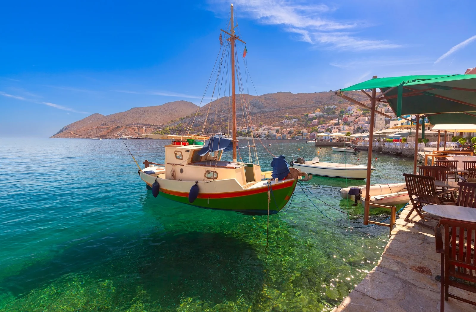 Serene harbor view with a traditional fishing boat on Symi Island, Greece