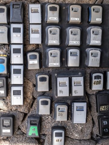 numerous security boxes with password controlled locking for the storage of keys of holiday flats at the entrance of a building, problem of holiday flats in cities, horizontal