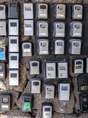 numerous security boxes with password controlled locking for the storage of keys of holiday flats at the entrance of a building, problem of holiday flats in cities, horizontal