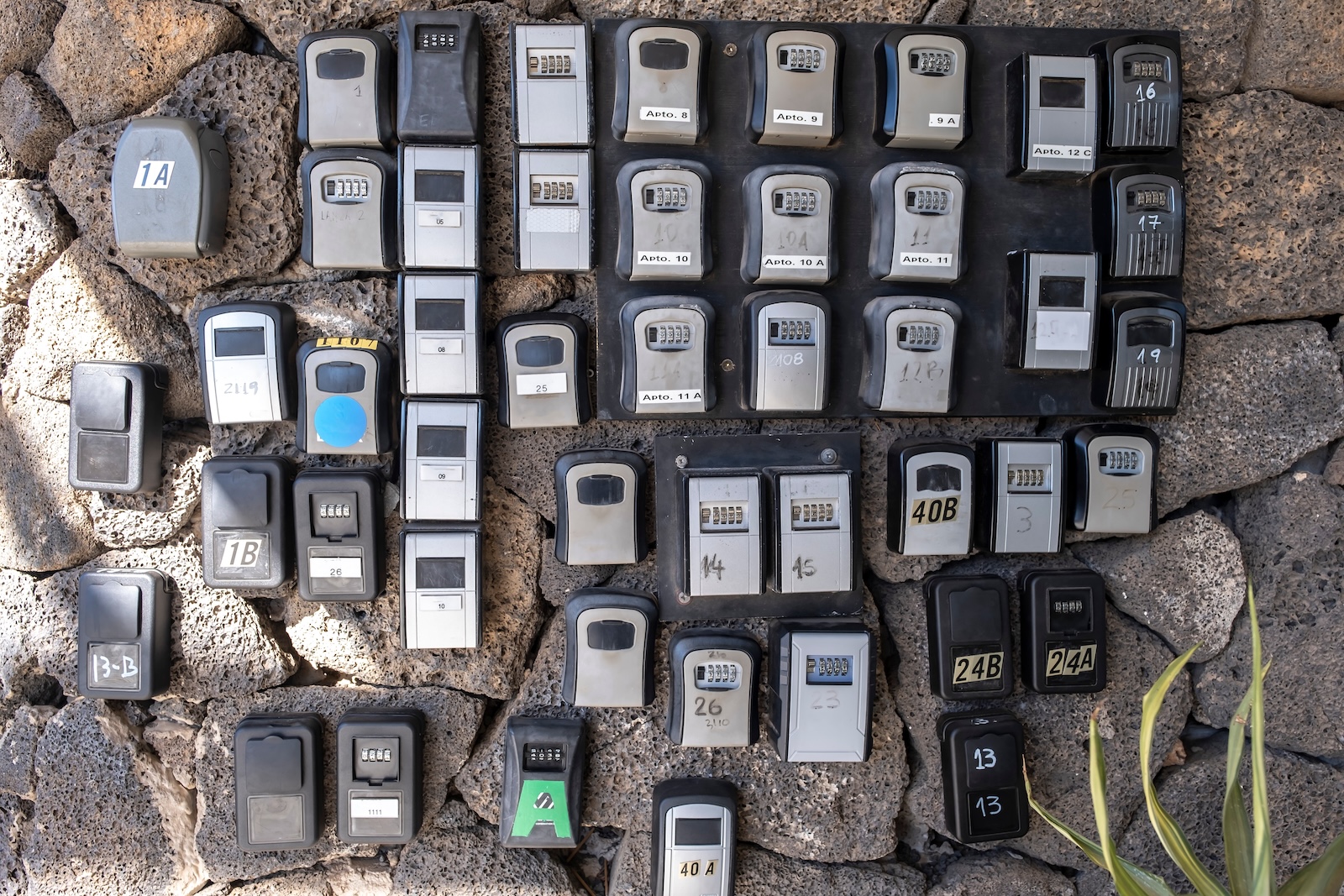 numerous security boxes with password controlled locking for the storage of keys of holiday flats at the entrance of a building, problem of holiday flats in cities, horizontal