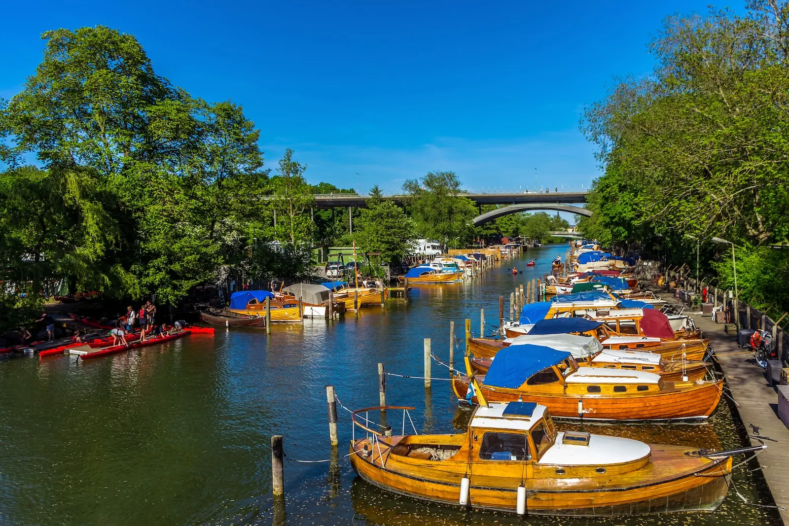 More Than Venice and Amsterdam: 15 Canal Cities That Will Steal Your Heart 6 Shiny polished wooden boats in channel between Langholmen and Sodermalm. Classic beautiful anchored yachts in the harbor, Stockholm, Sweden. View of old boats and kayaks by shores in bright sunny day.
